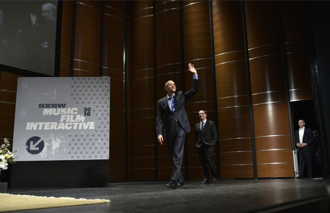US President Barack Obama waves as he and Texas Tribune editor Evan Smith (C) arrive for a South by Southwest Interactive at the Long Center for Performing Arts in Austin, Texas on March 11, 2016. / AFP / MANDEL NGAN