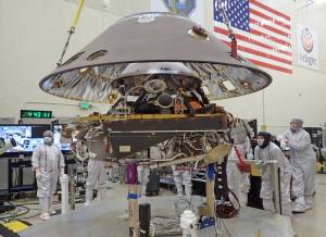 The back shell of the InSight spacecraft is lowered onto the lander in a clean room at Lockheed Martin.