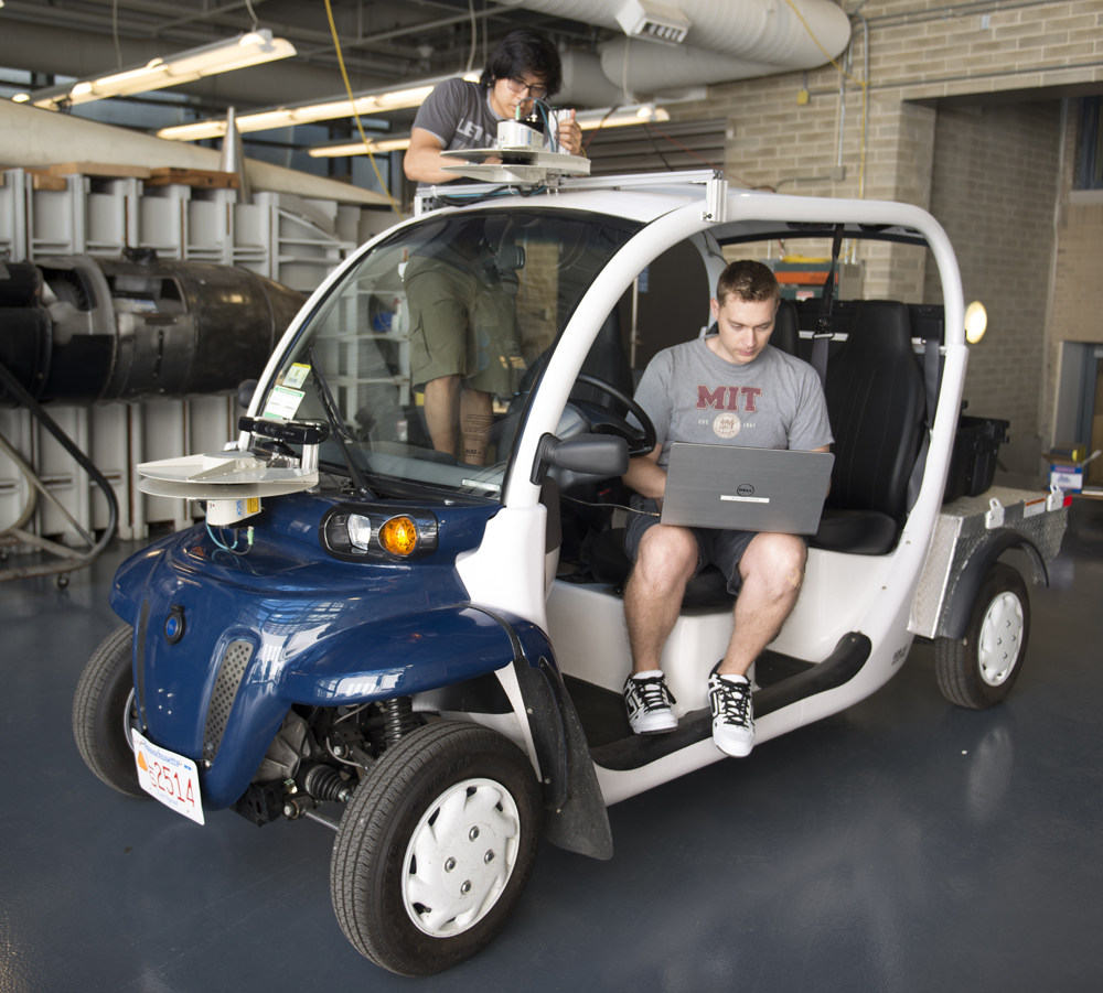 Graduate student Justin Miller and undergrad Wally Wibowo of the Aerospace Controls Lab working on vehicles outfitted with sensors that match those of self-driving cars. This work is part of the Ford-MIT Alliance and aims to predict pedestrian behaviors on short time-scales while also providing data to support a mobility-on-demand system for the MIT campus.