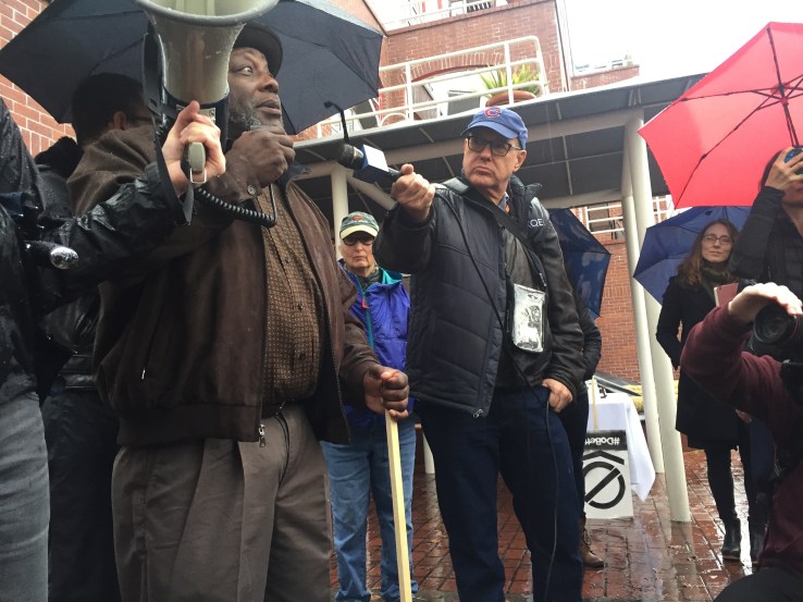Community organizer Dorsey Nunn speaks to the crowd of protesters outside Palantir HQ.